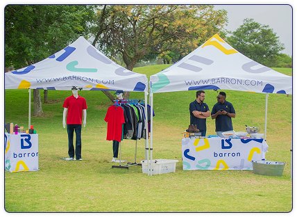Barron branded outdoor event setup with promotional tents, custom apparel displays, and corporate merchandise showcasing branding solutions